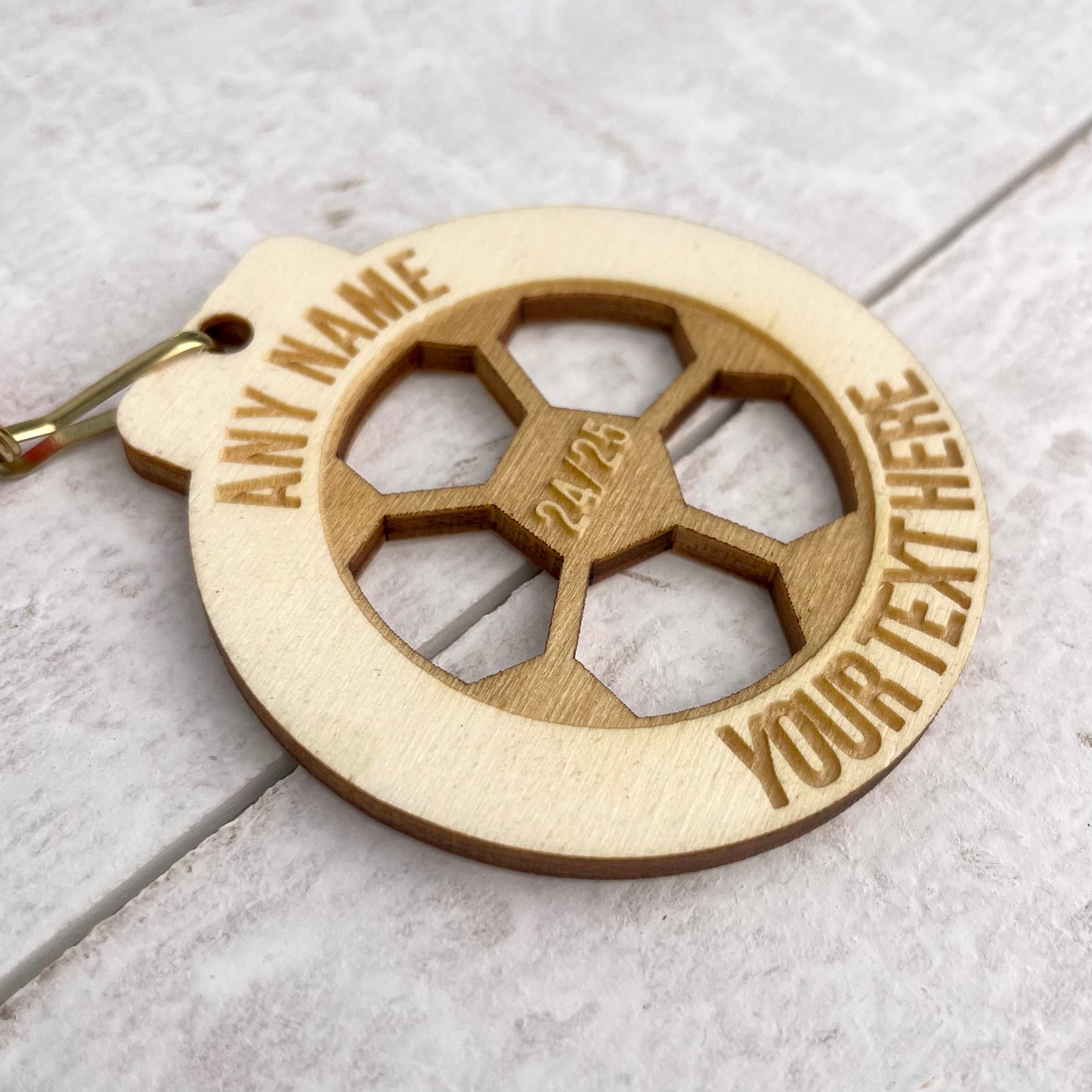 Customisable wooden medal with engraved text at the top, in the centre and at the bottom. This comes with a striped blue, white and red ribbon.
