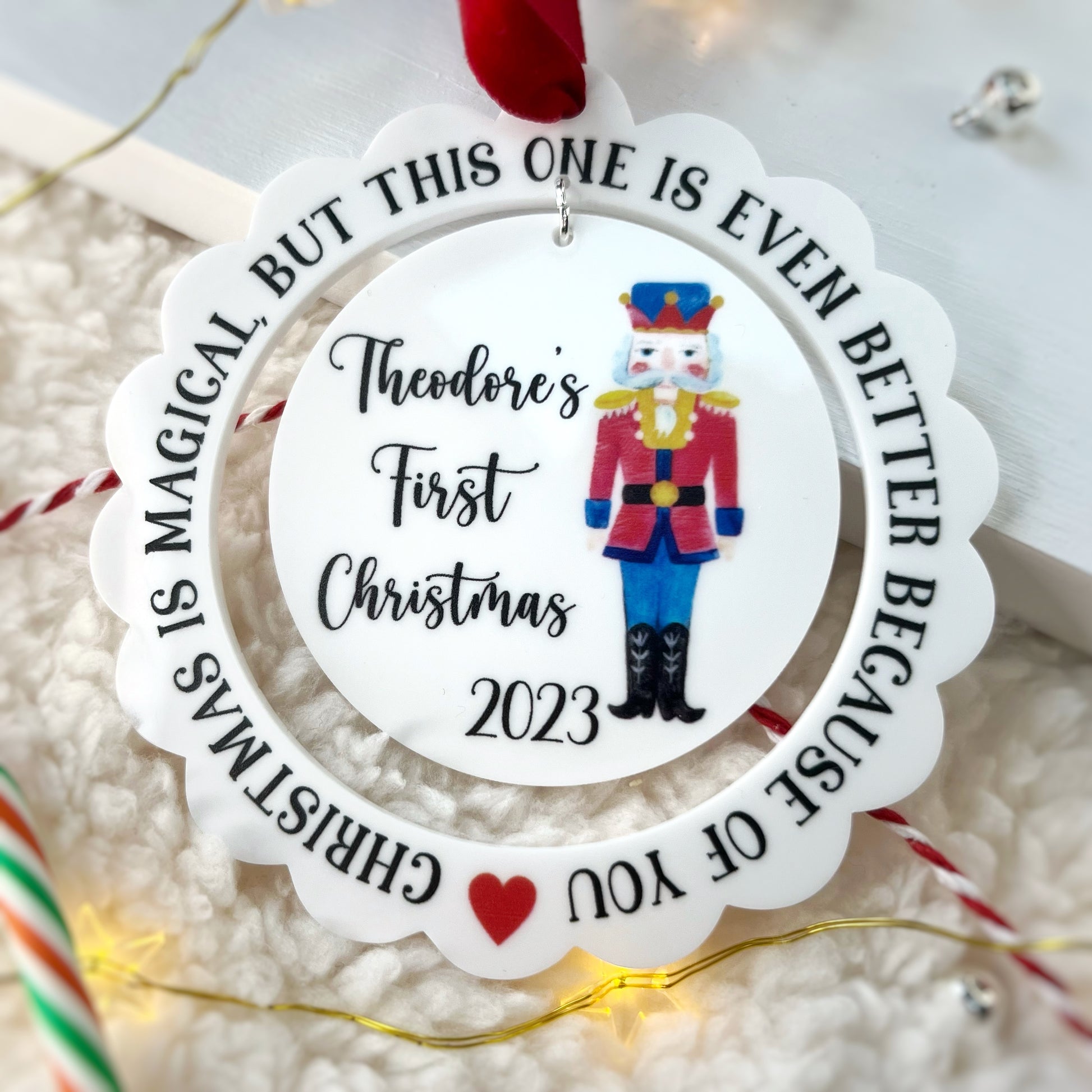 Baby's first christmas nutcracker decoration, personalised with a childs name and the year they were born. Scalloped edge and pretty watercolour illustration of a nutcracker.