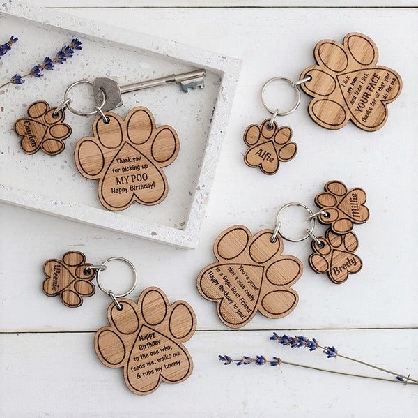 Wooden keyrings in the shape of dog pawprints. Engraved with funny quotes and puns. Personalised with the pets name. A gift for Father's Day from a dog. Made by The Bespoke Workshop.