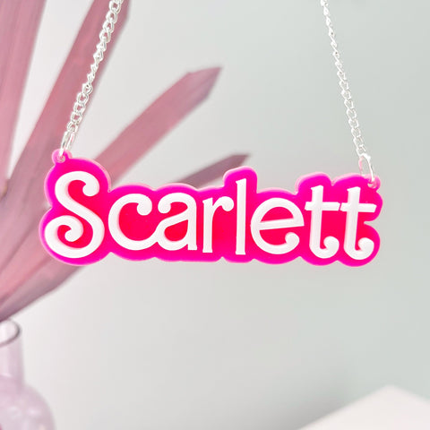 Laser cut custom acrylic name necklace in Barbie pink and white lettering. Made by The Bespoke Workshop