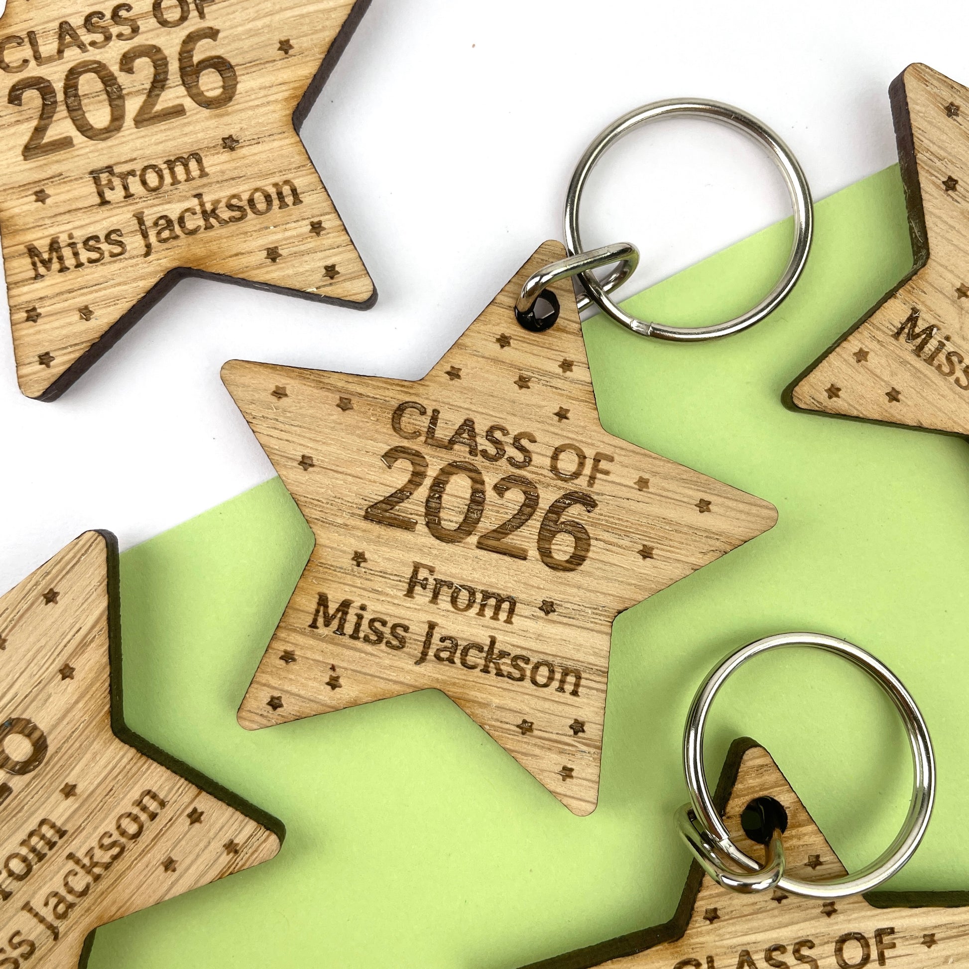 A wooden star-shaped keyring with engraved text celebrating 'Class of 2026', along with the name of the teacher.