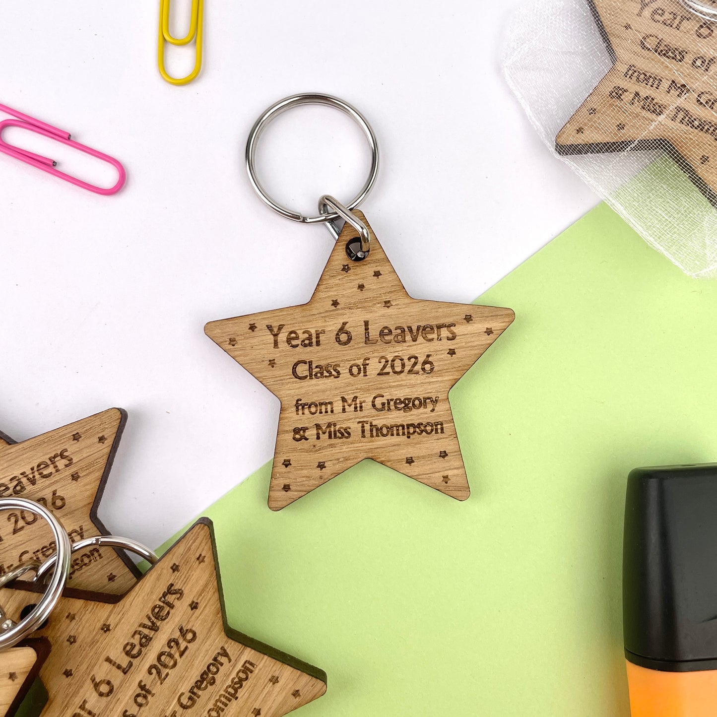 A wooden star-shaped keyring with engraved text celebrating 'Year 6 Leavers' and 'Class of 2026', along with the names of the school and teacher.