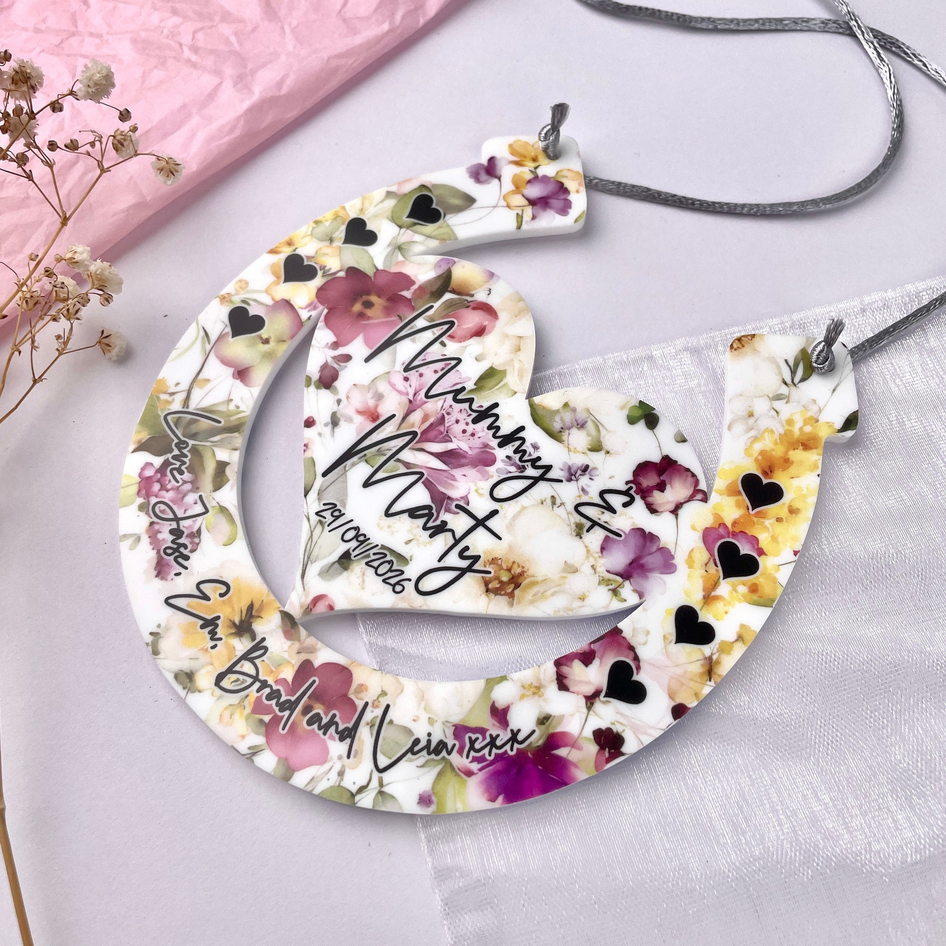 Floral horseshoe design with printed names with a floral background front shot 