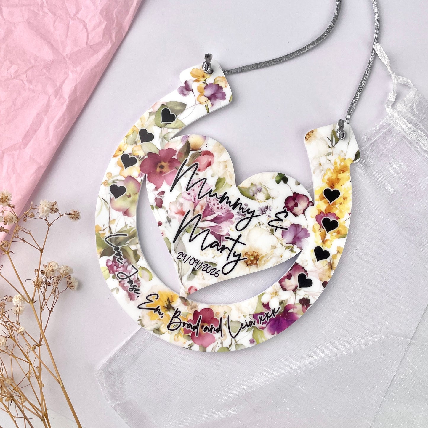 Floral horseshoe design with printed names with a floral background front shot 
