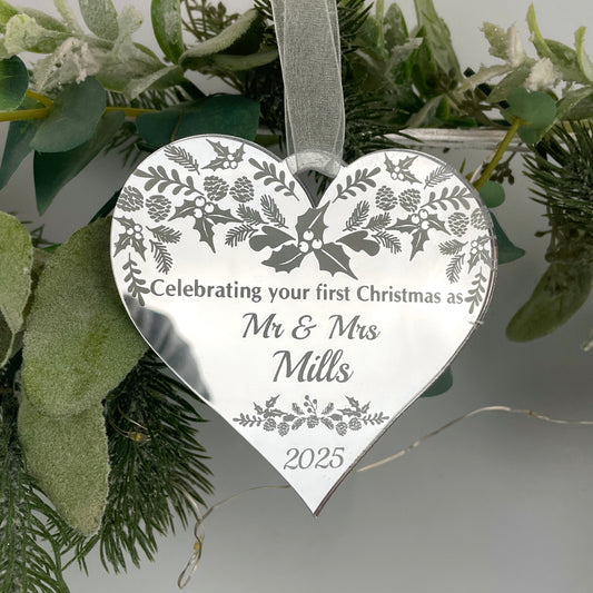 A heart-shaped, silver mirrored acrylic decoration with a winter pattern, personalized with engraved text including names and a date.