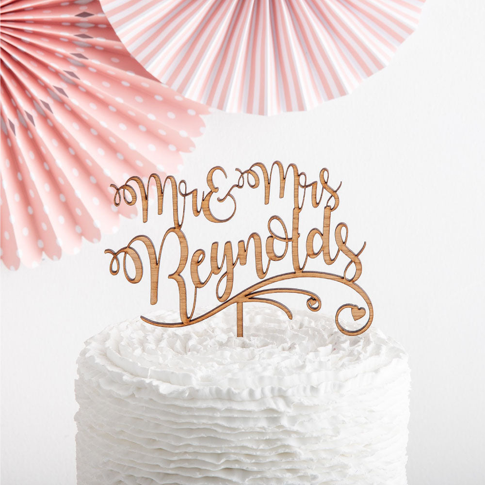 Mr and Mrs personalised cake topper in a white cake with party decorations in the background
