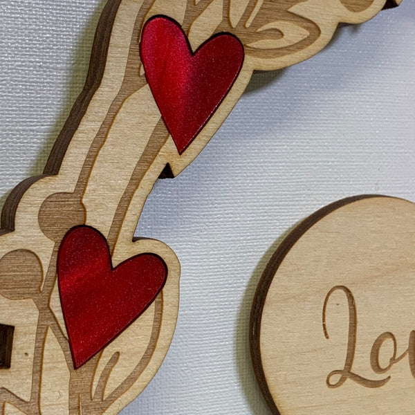 Close up of wooden wreath inlaid with red acrylic hearts - The Bespoke Workshop